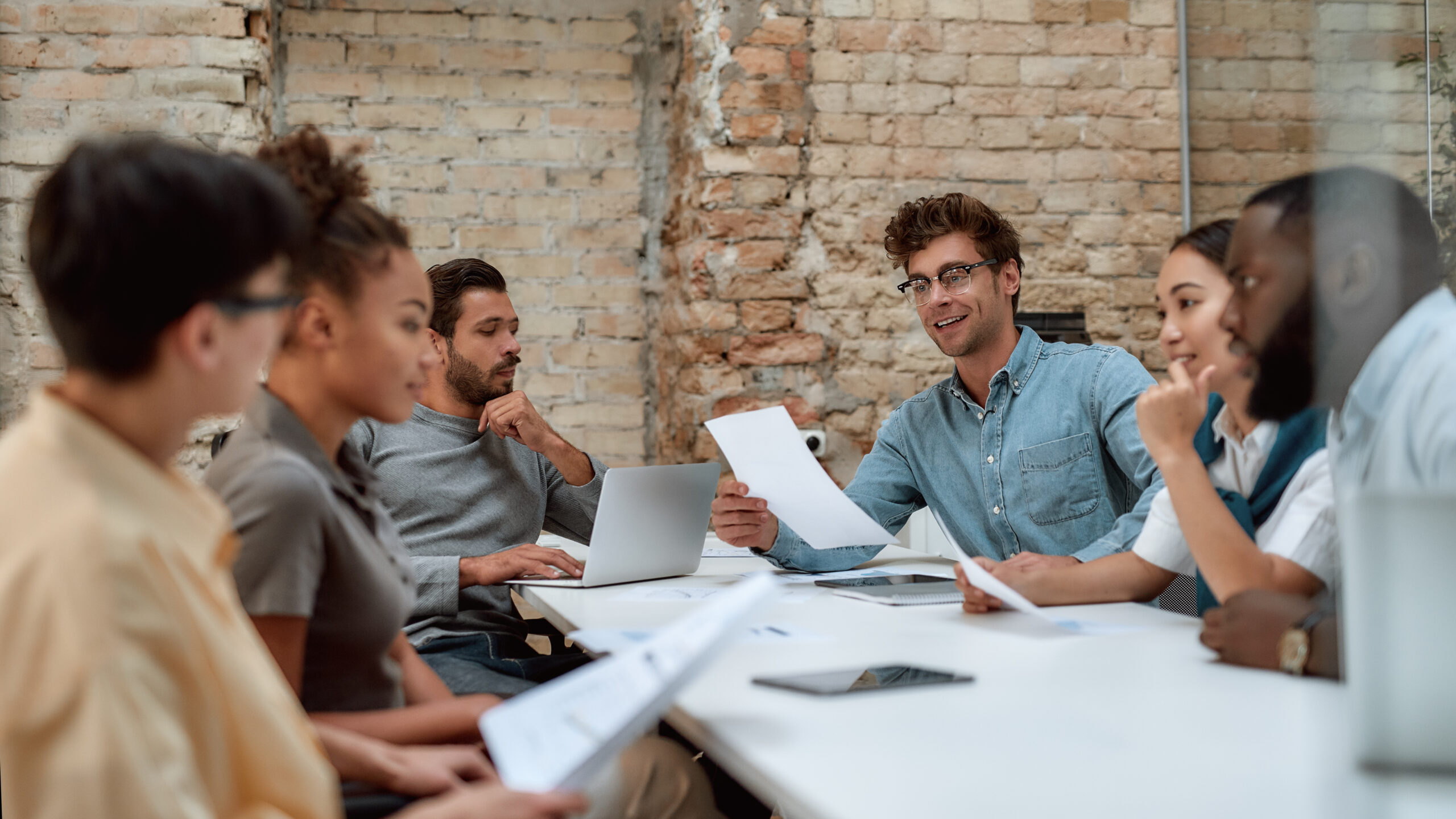 Exemple de réunion lors d'un séminaire. Quatre personnes sont en train de discuter tout en analysant des données.