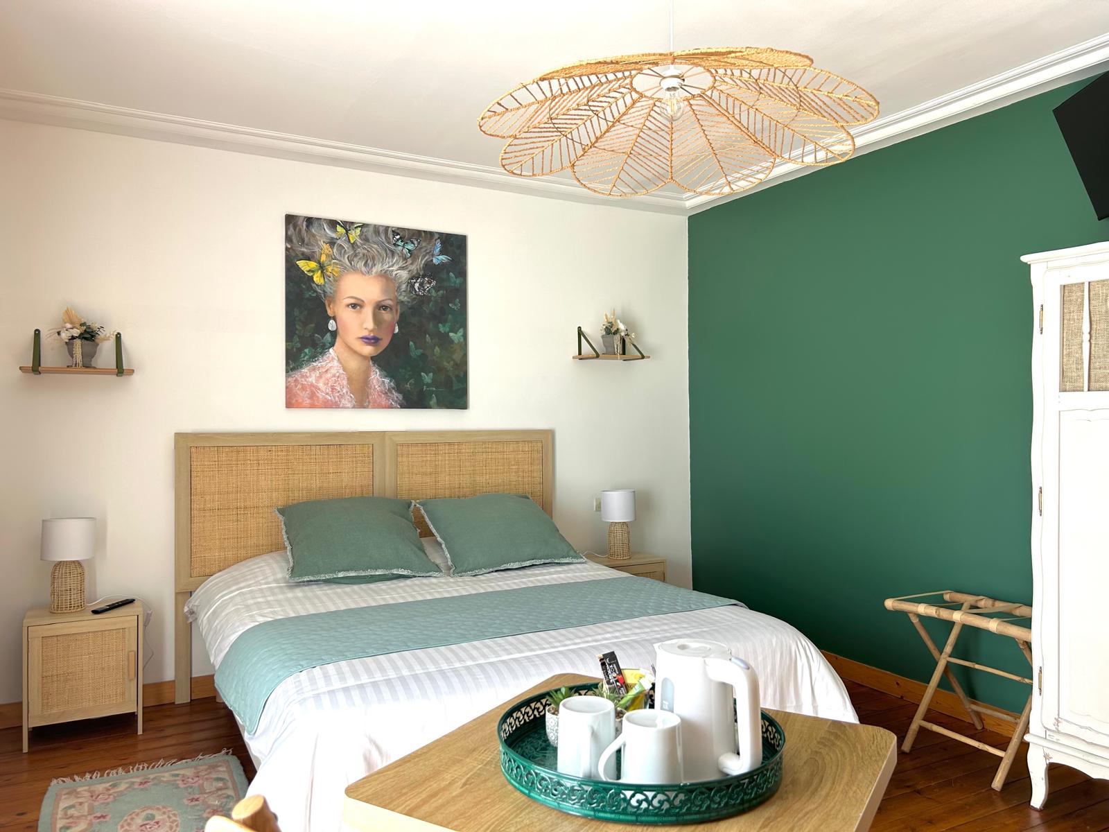 La chambre Fleur avec son lit deux places, sa décoration simple et moderne avec quelques touches de vert.