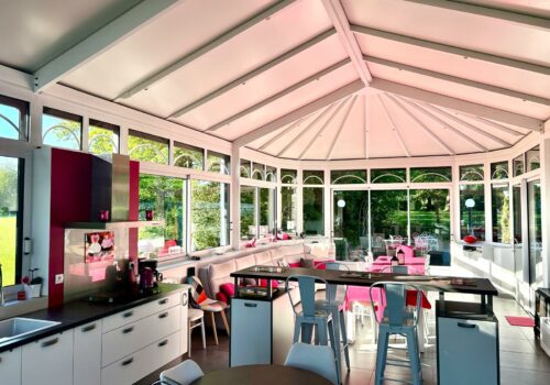 Le gîte Véranda avec un grand salon ainsi qu'une cuisine. Tons rose fuschia.