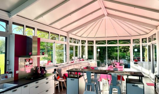 Le gîte Véranda avec un grand salon ainsi qu'une cuisine. Tons rose fuschia. 